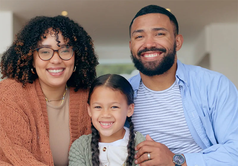 Parents and daughter smiling at camera